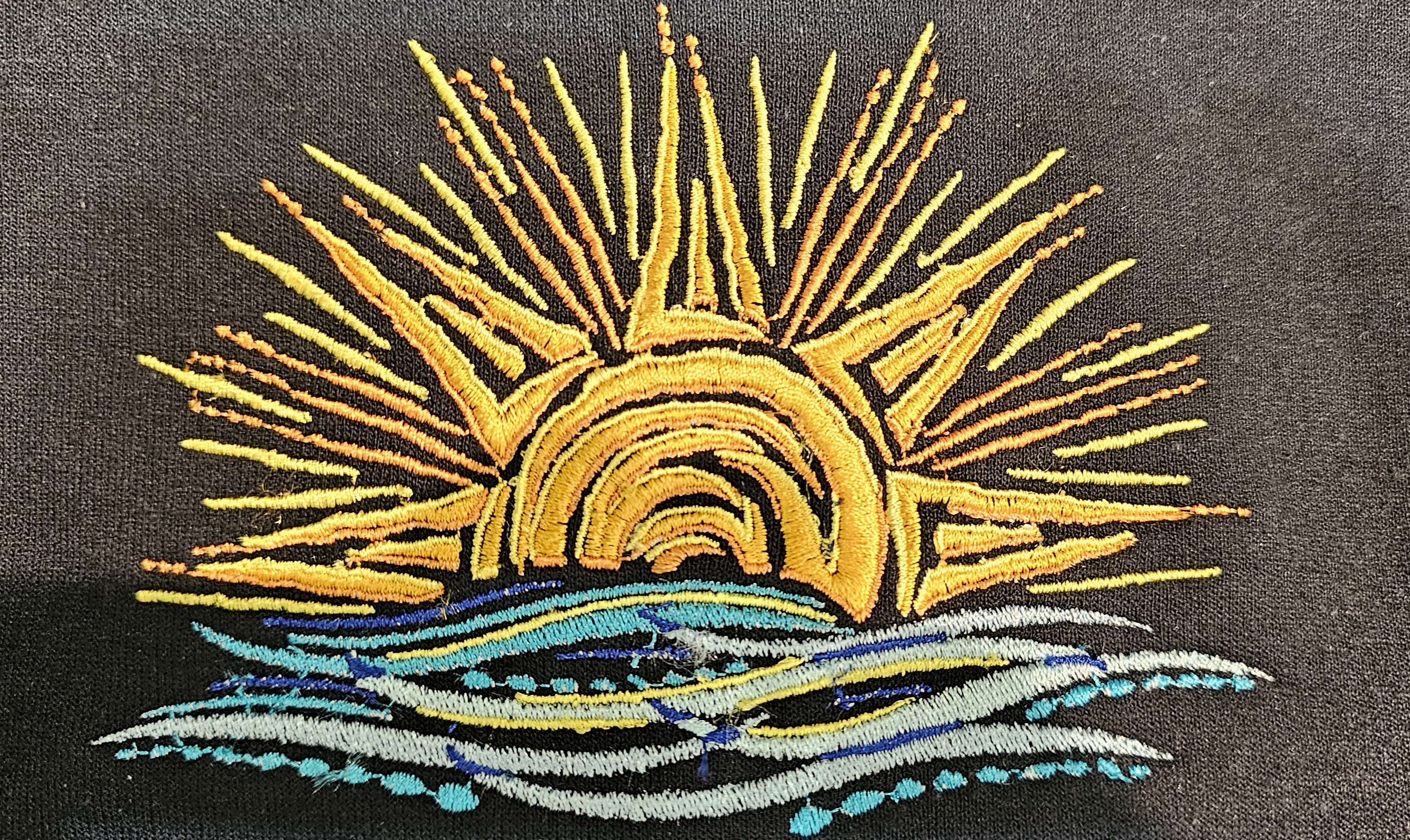 Sunset embroidery stitched on black apparel