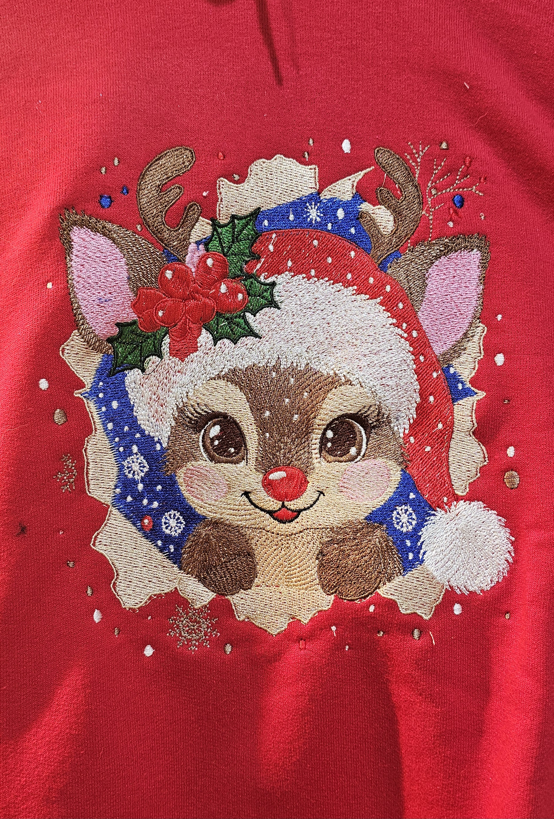 Christmas reindeer wearing a Santa hat embroidered on a red sweatshirt