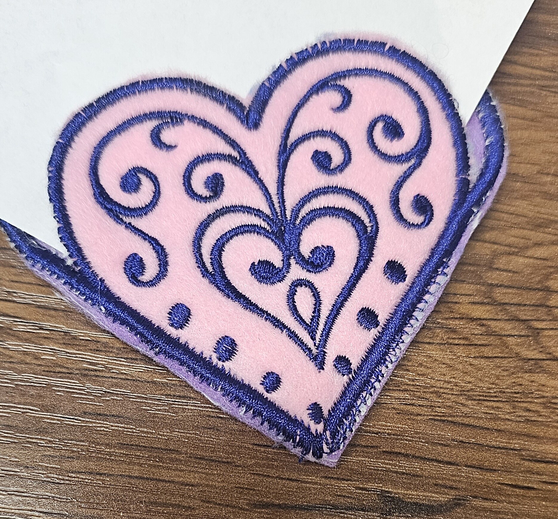 Pink heart-shaped embroidered corner bookmark with navy scrollwork
