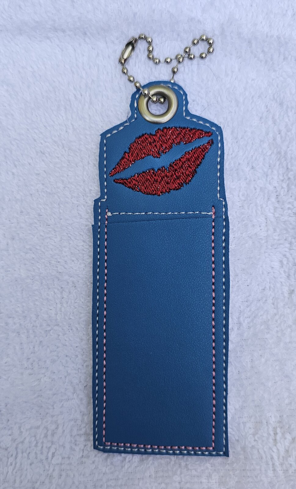 Blue lip balm holder embroidered with red lips