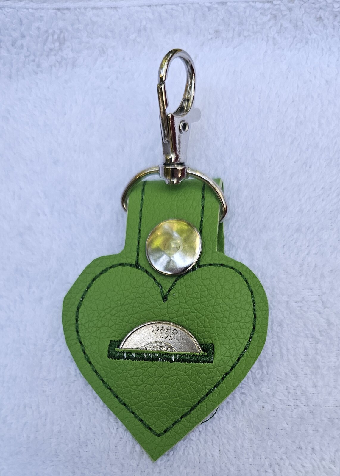 Green heart-shaped key fob with a slot holding a quarter
