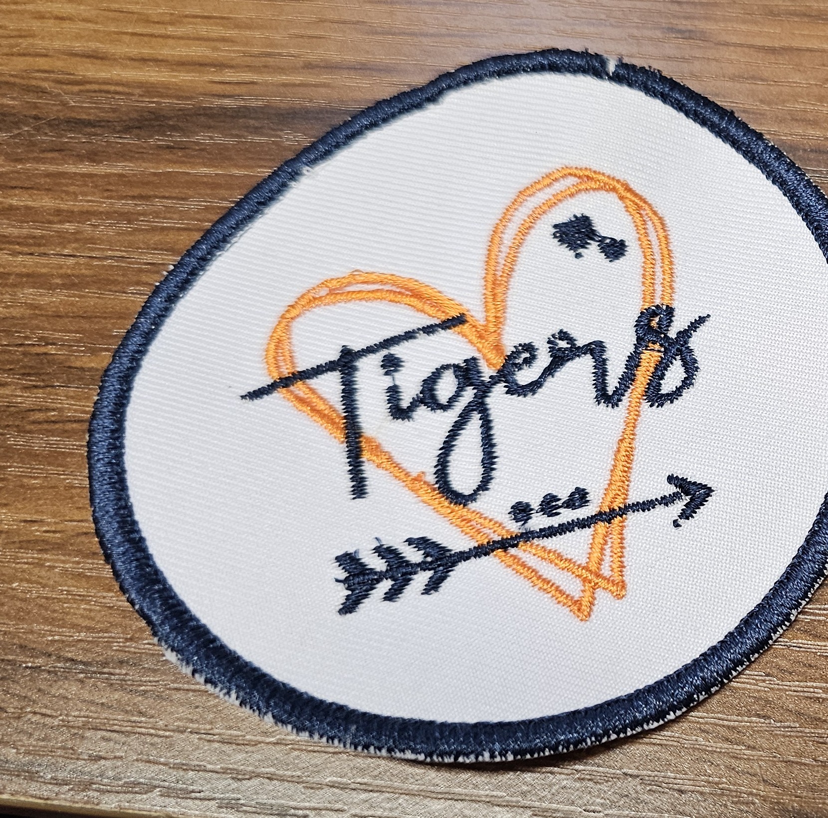 Round embroidered tiger patch on a wood table